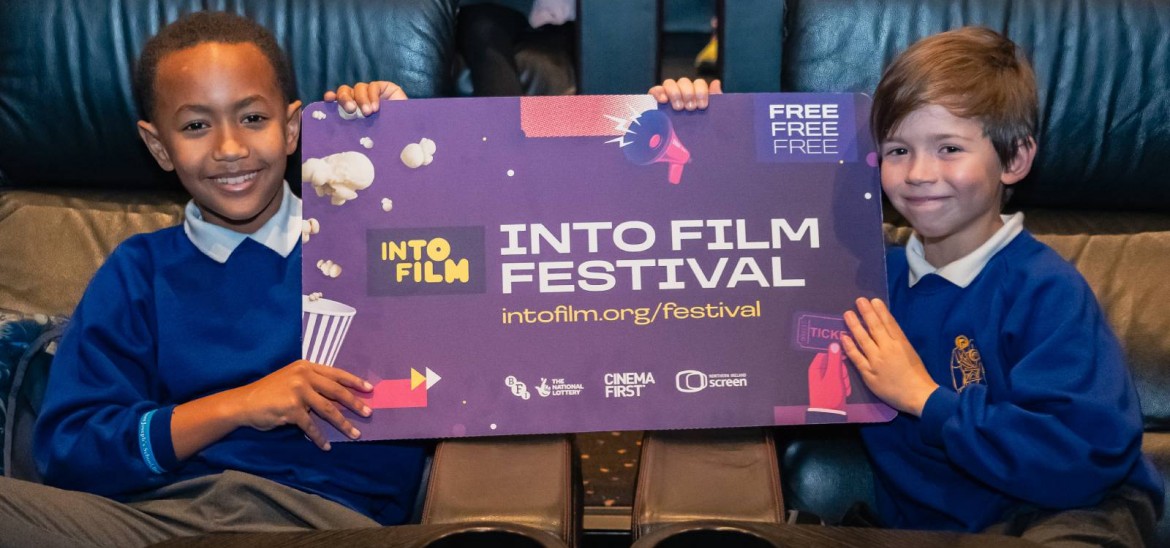 Two boys pose with our Into Film Festival poster.