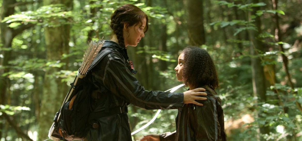 Two girls in a forest, the elder resting her hand on the younger's shoulder