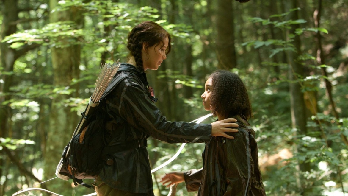 Two girls in a forest, the elder resting her hand on the younger's shoulder