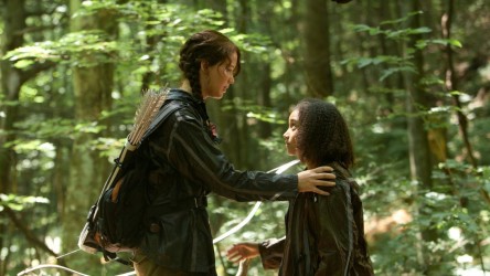 Two girls in a forest, the elder resting her hand on the younger's shoulder