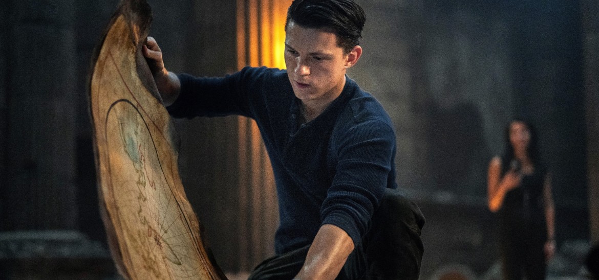 A young man in a blue shirt looks at an ancient map