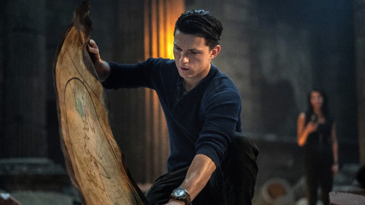 A young man in a blue shirt looks at an ancient map