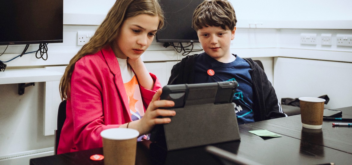 Two YAC members looking at a tablet (Glasgow, 2022)