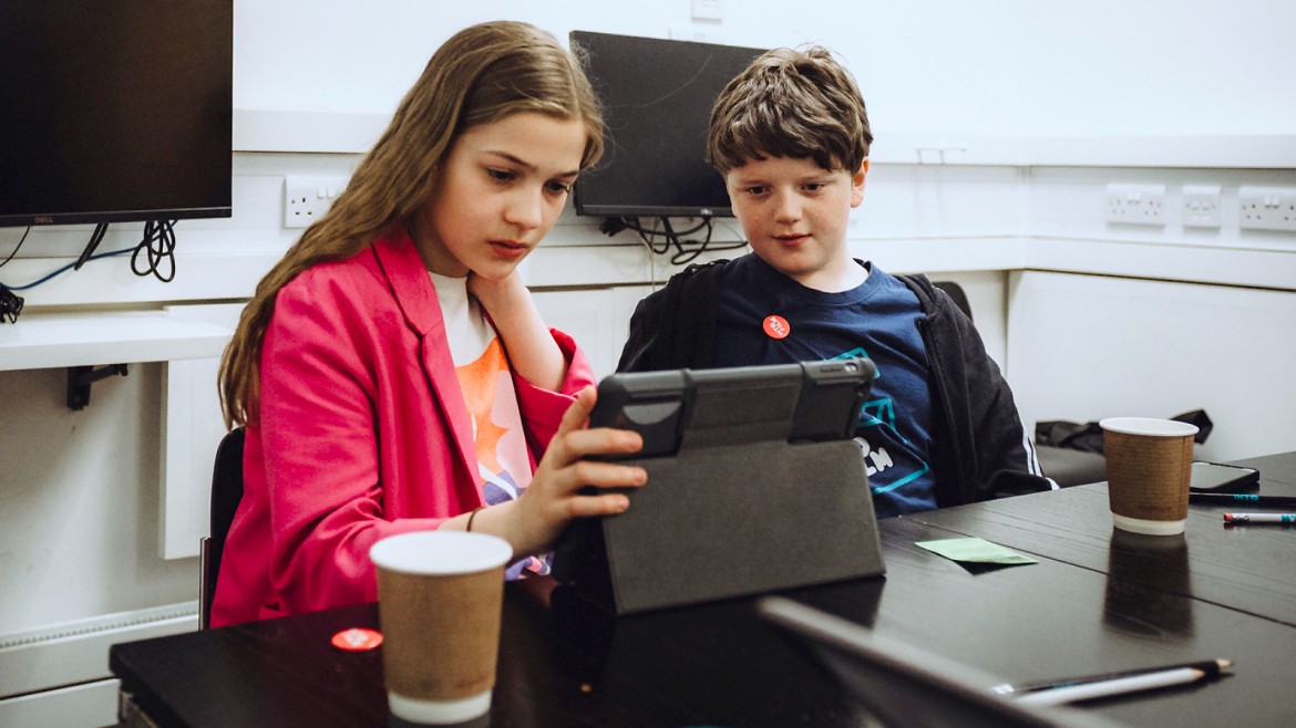 Two YAC members looking at a tablet (Glasgow, 2022)