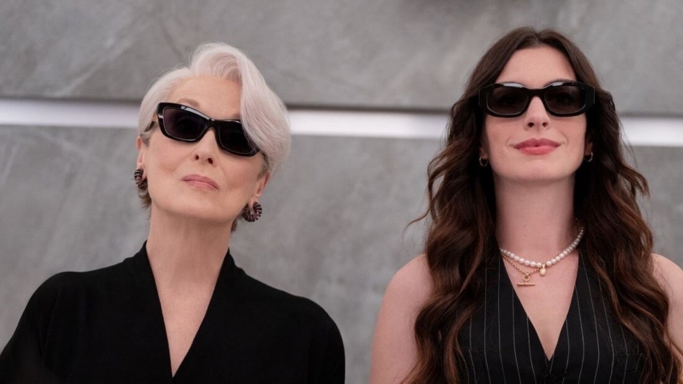 Two women in stylish black clothing and black sunglasses