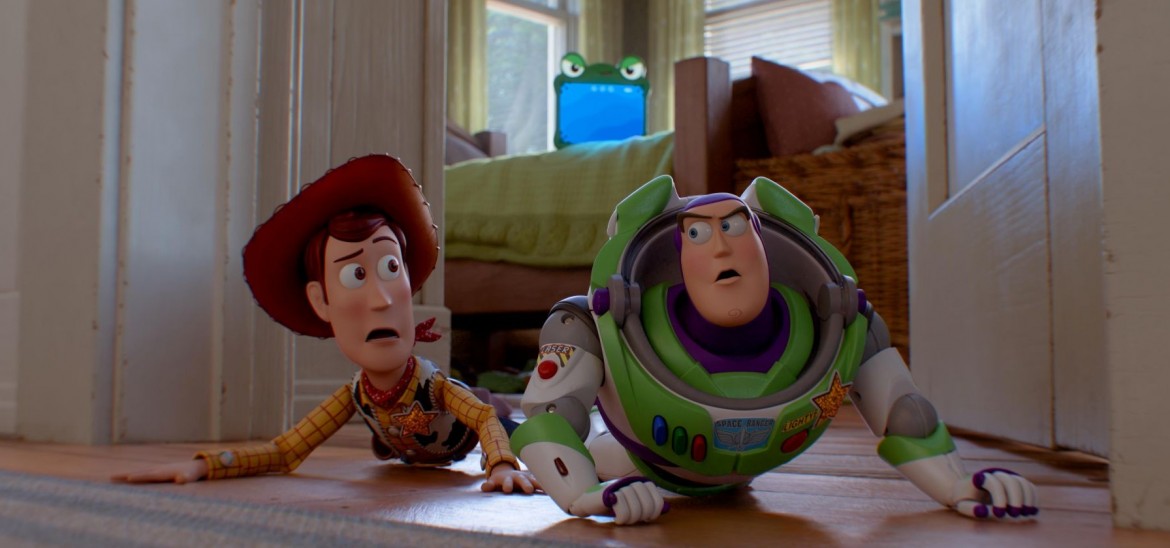 A toy cowboy and a toy astronaut lie on the floor