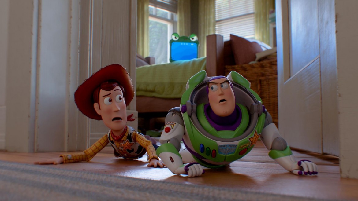 A toy cowboy and a toy astronaut lie on the floor