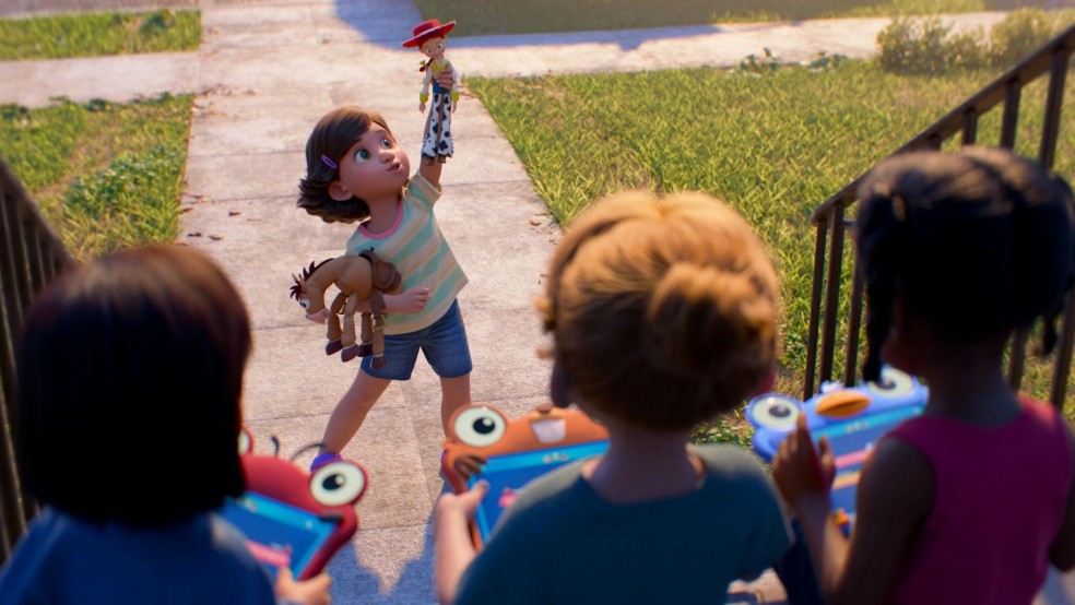 A girl plays with her toys in front of other children with tablets