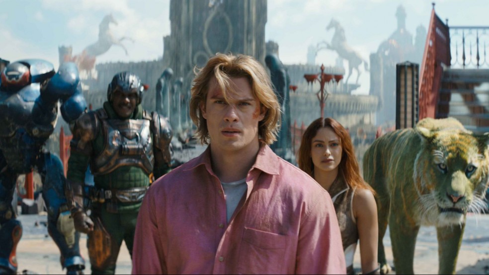 A young man looks serious standing in front of a group of warriors