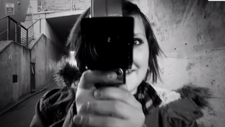 Black and white image of girl with a cinecamera.