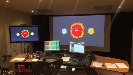 Large monitors displaying cartoon depictions of viruses 