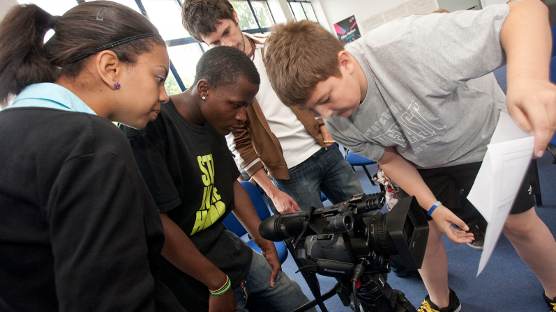 Boys and girls filming a piece of paper