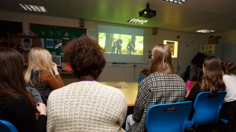 5 people in film club watching screen