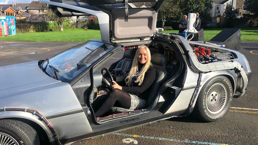 Jemma Evans, Teacher of the Year 2022, sitting in the Delorean