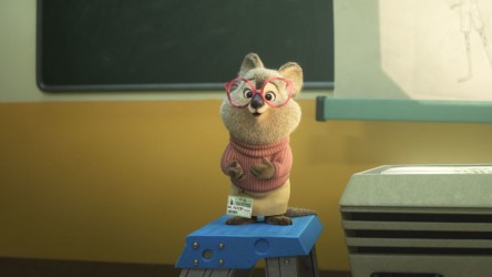 A small rodent wearing glasses talking in a classroom.